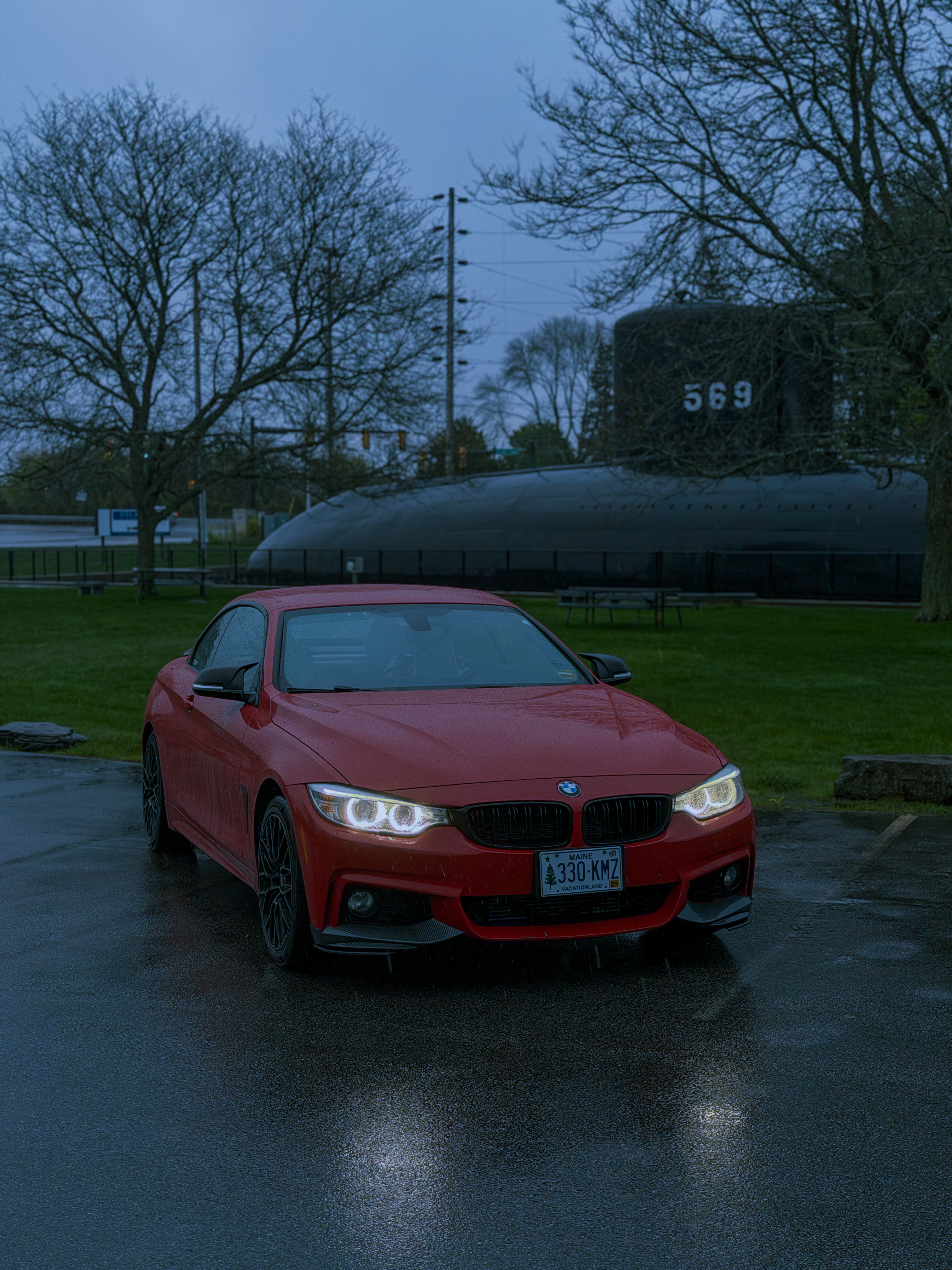 Leroy's red 2016 BMW 428i parked on a wet lot at dusk